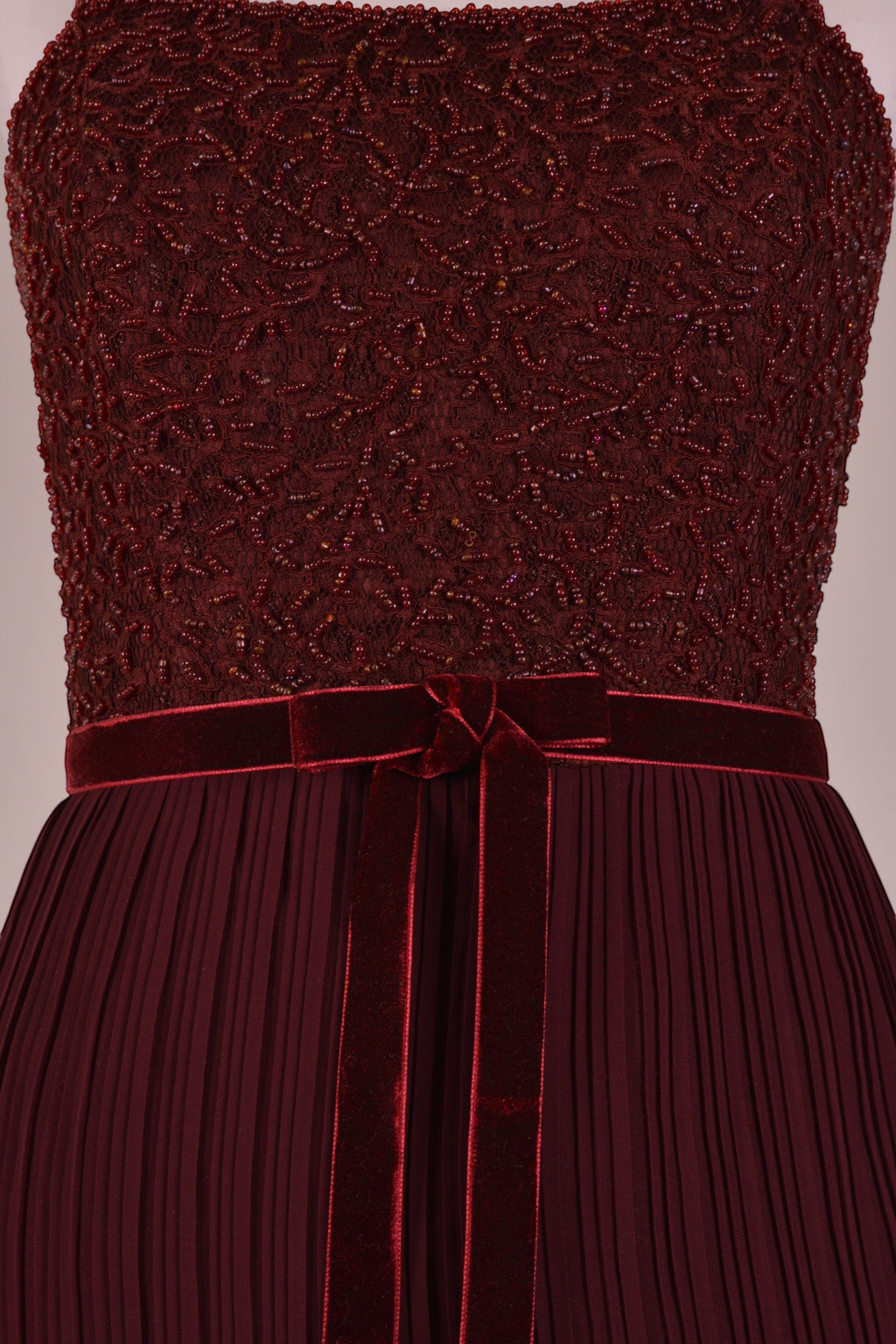 Ageless.ee deep burgundy tiered pleated maxi dress with embellished bodice, velvet waistband, and flowing skirt.
