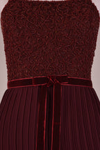 Ageless.ee deep burgundy tiered pleated maxi dress with embellished bodice, velvet waistband, and flowing skirt.