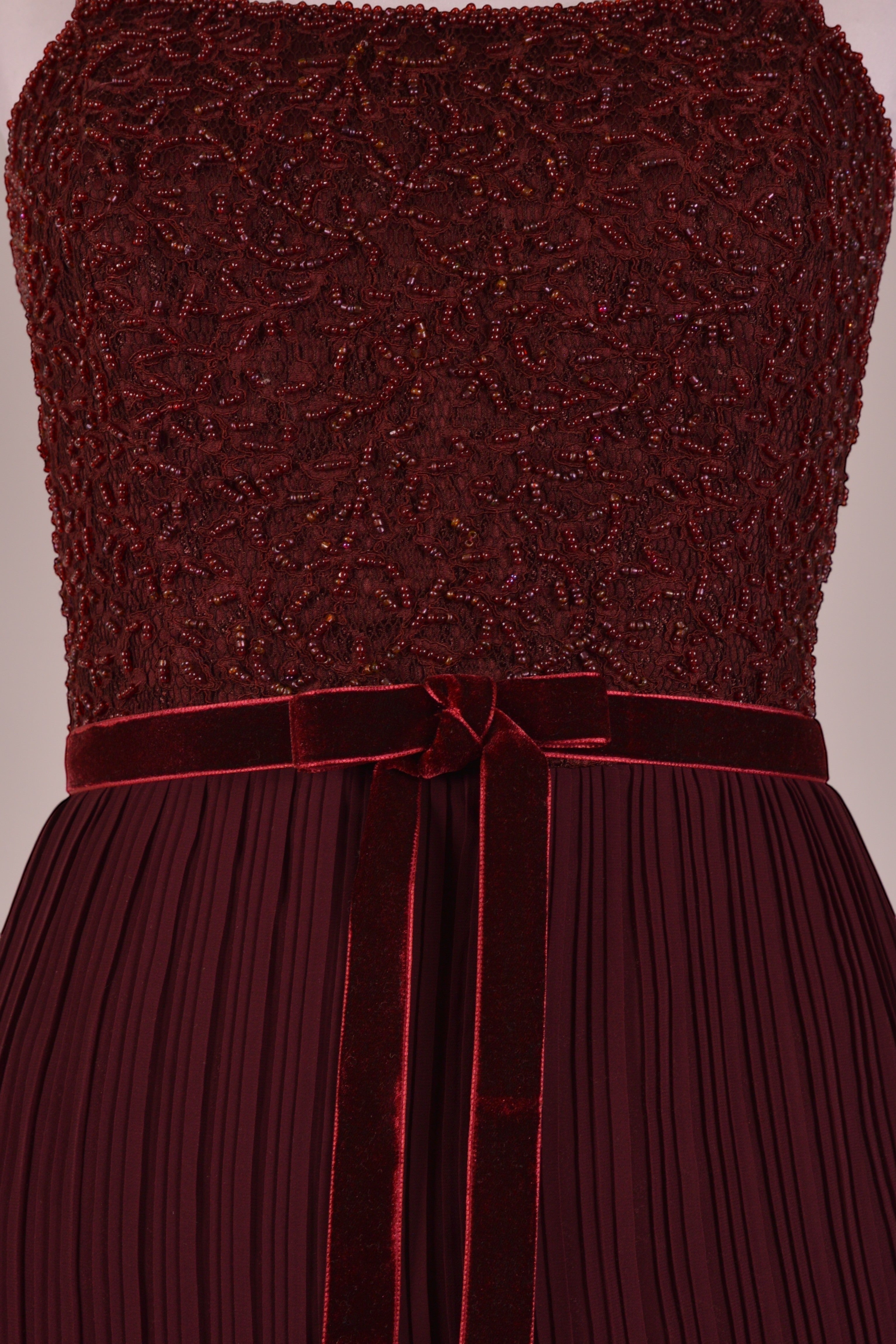 Ageless.ee deep burgundy tiered pleated maxi dress with embellished bodice, velvet waistband, and flowing skirt.